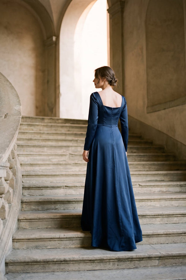 Woman in a navy satin gown on a stone staircase